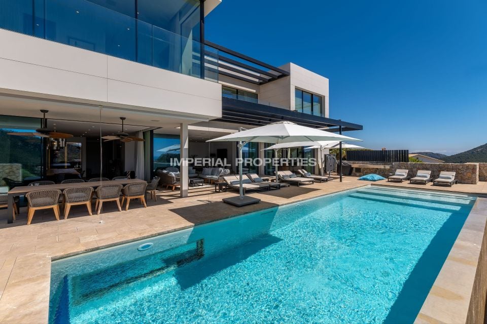 Outdoor pool, covered dining table and lounge umbrellas on the villa terrace