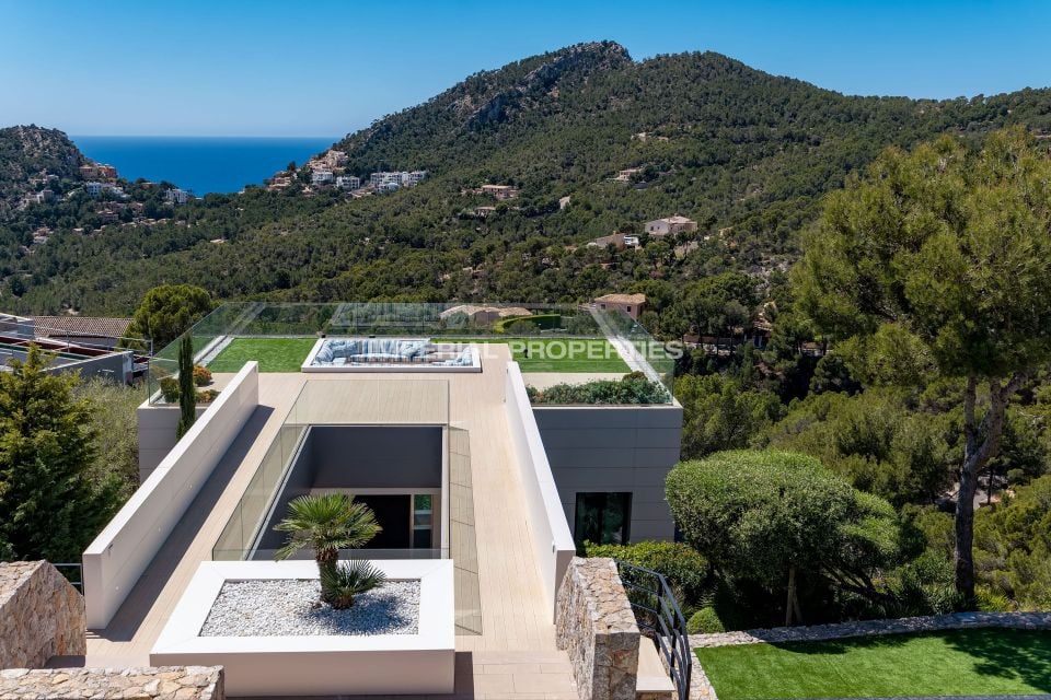 Roof terrace with a glass opening, planting and a view toward the sea